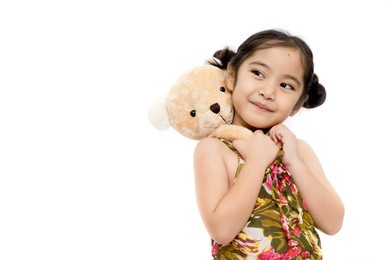 pretty girl playing with bear doll on white background