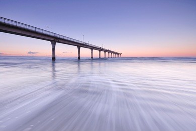 sunset and wave flow in new brighton pier, christchurch new zealand