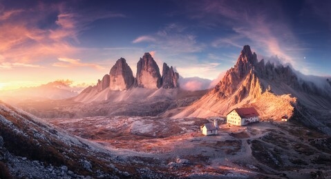 mountain valley with beautiful house and church at sunset in autumn. landscape with buildings, high rocks, colorful sky, clouds, sunlight. mountains in tre cime park in dolomites, italy. italian alps