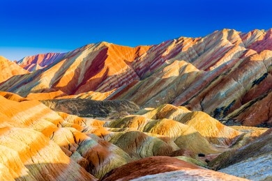 amazing scenery of rainbow mountain and blue sky background in sunset. zhangye danxia national geopark, gansu, china. colorful landscape, rainbow hills, unusual colored rocks, sandstone erosion