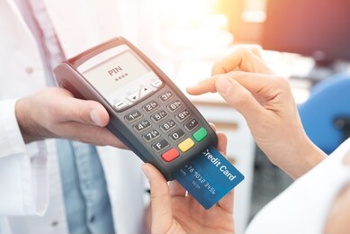 payment by credit card with terminal. woman enters the pin code