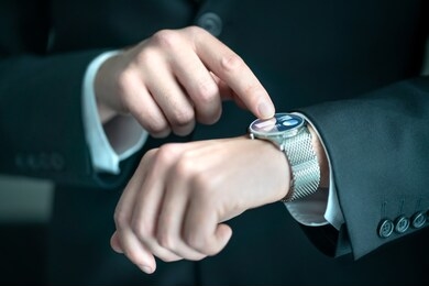 businessman wearing smart watch with banking, finance or business report app. man in suit using wearable gadget for work. hybrid smartwatch with touch screen and metal band. people with wearables.