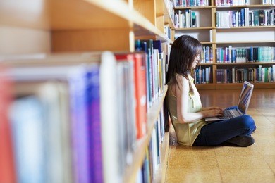  young smiling student using her laptop in a library