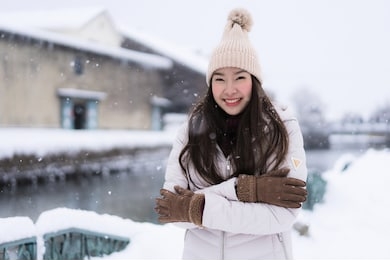 beautiful young asian woman smile and happy with travel trip at otaru canal hokkaido japan in snow and winter season