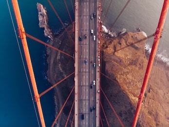 aerial view of golden gate bridge in foggy visibility during evening time, metropolitan transportation  infrastructure, birds eye view of automotive car vehicles on road of suspension construction 