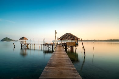 wooden bar in sea and hut with clear sunrise sky in koh mak at trat, thailand. summer, travel, vacation and holiday concept.