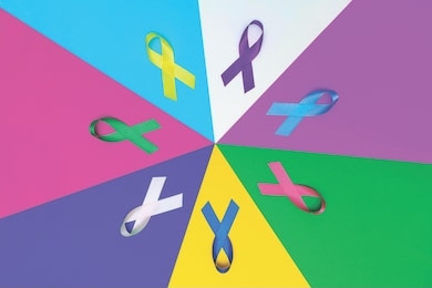 world cancer day background. colorful ribbons, cancer awareness. blue surface from above. cmyk print banner.