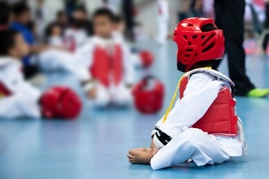 kid sport athlete taekwondo with protective gear red head vast guard warm up on floor ready to fight for international competition, karate