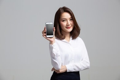 young beautiful woman holding blank screen smart phone on white background