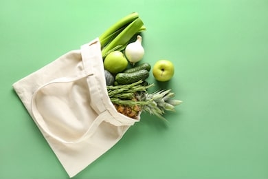 eco bag with products on color background