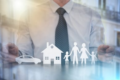 insurer protecting a family, a house and a car with his hands; multiple exposure