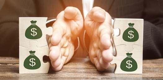 businessman separates the wooden puzzle with a picture of money. the concept of financial management and distribution of funds. saving and investing. property division. divorce and legal services