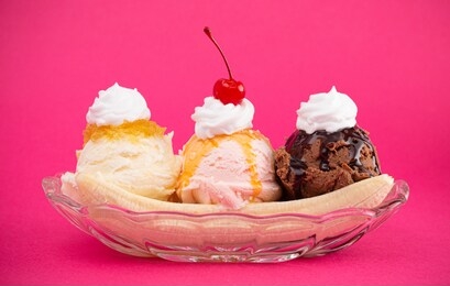 a classic banana split on a bright pink background