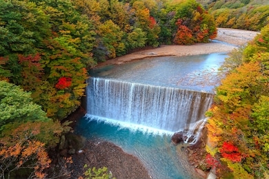 beautiful landscape scene of waterfall and colorful leaves in autumn foliage season. matsukawa river, hachimantai, iwate prefecture, tohoku, japan. travel and holiday vacation background concept.