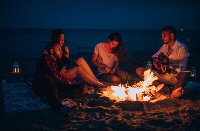 group of best friends singing and having fun camping together, low key, dark image