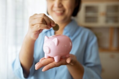 hand putting coin money to piggy bank saving, close up of old as