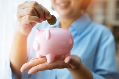 hand putting coin money to piggy bank saving.