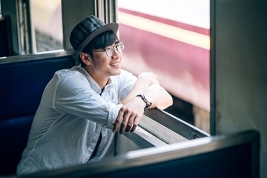 asian man is traveler, he is waiting for their train. outdoor adventure travel by train concept. bangkok, thailand. happy/positive/healthy hike/travel/wanderlust concept