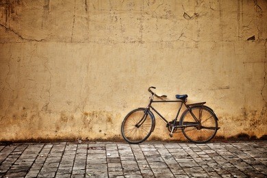 old rusty vintage bicycle near the concrete wall