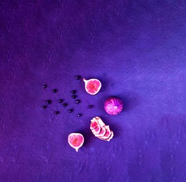sandwiches with fresh figs, goat cheese and blueberries. creative layout of the whole and sliced figs on neon background. copy space, closeup