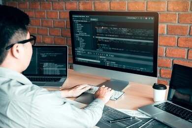 asian man working code program developer computer web development working design software on desk in office.