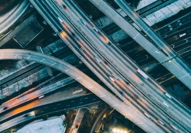 aerial view of city landscape with autobahn motorway in metropolis, bird's eye evening view. automobiles moving at street with modern automotive expressway. interchange road highway, junctions freeway