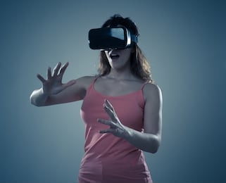 amazed attractive woman using vr headset glasses touching and interacting with virtual reality world. feeling excited exploring and having fun in 360 vr simulation. innovation and new technology.