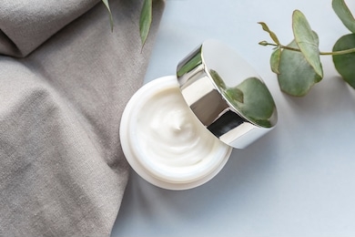 jar of natural cream and eucalyptus branch on table