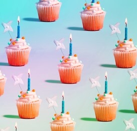 tasty celebratory cupcakes with decorative lit candles