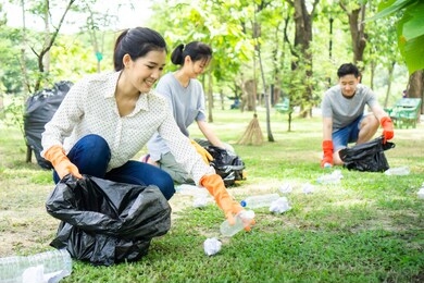 team volunteers collecting garbage in public park. environmental protection concept.