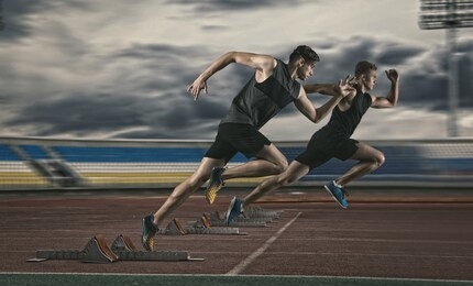 two man sprinter leaving starting blocks on the athletic track 
