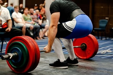 men powerlifter deadlift competition in sport gym with fans