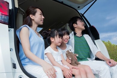 family sitting in car trunk