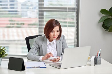 asian businesswoman or accountant working pointing graph discussion and analysis data charts and graphs and using a calculator to calculate numbers. business finances and accounting concept