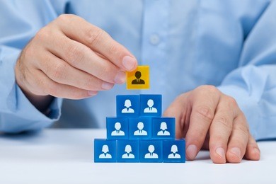 human resources and corporate hierarchy concept - recruiter complete team by one leader person (ceo) represented by gold cube and icon. 