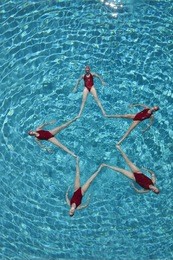 elevated view of synchronised swimmers forming a star shape in pool