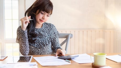 beautiful asian female accountant using calculator making calculations savings, financial or accounting concept. copy space