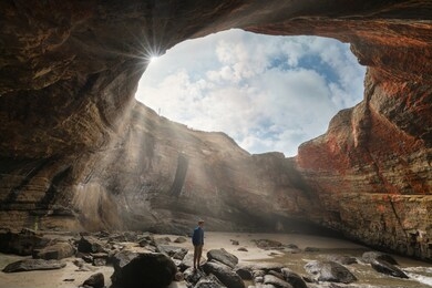 devil's punch bowl at low tide and a person exploring it
