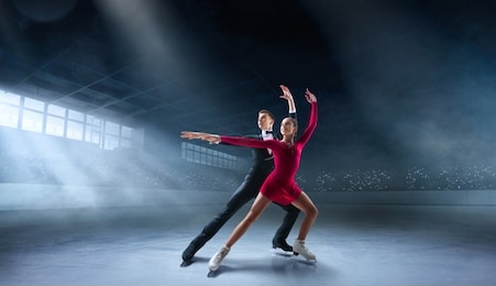 figure skating couple in professional ice arena.