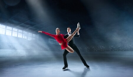 figure skating couple in professional ice arena.