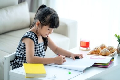 asian preschool student do homework by reawing by a color, this image can use for girl, study, school, kid, student and education concept