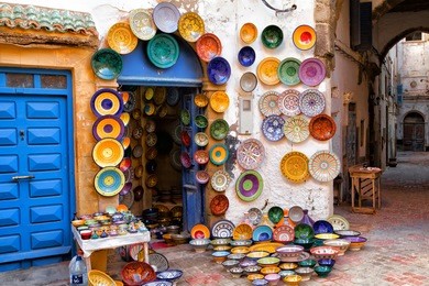 colorful moroccan faience pottery dishes on display in an alley outside a shop in the scenic fishing village of essaouira, morocco
