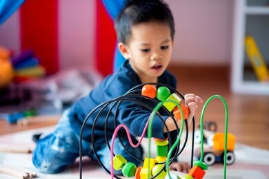 asian baby playing the wooden toys in the living room.