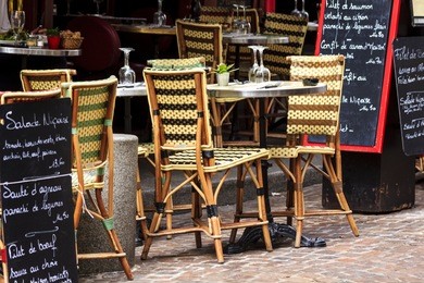 cafe at rue mouffetard in paris - traditional wicker furniture and menu boards exposed on the pavement, paris, france