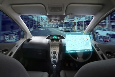 autonomous car with hud graphic of navigation system driving on street in the city by self driving mode. no driver car and ai technology with transportation concept.