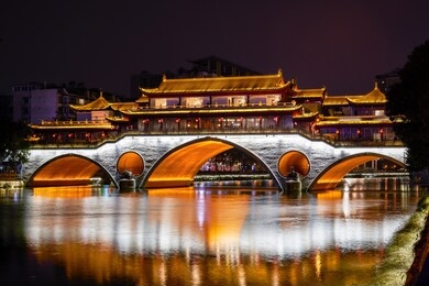 popular tourist desitnation: anshun bridge casting its light over jin river at night. chengdu, sichuan, china.