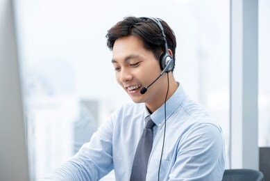 smiling handsome asian man working in call center office as a customer service operator