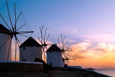 sunset with famous windmills on mykonos island, greece