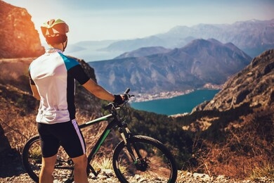 athletic sportsman cyclist standing with bike enjoying beautiful view.