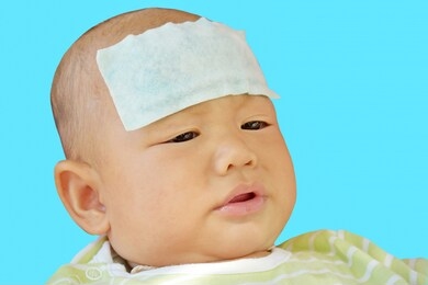 baby have a fever and are lying crying on a blue background. relieve heat in infants with fever. concept for health and medical. isolate.